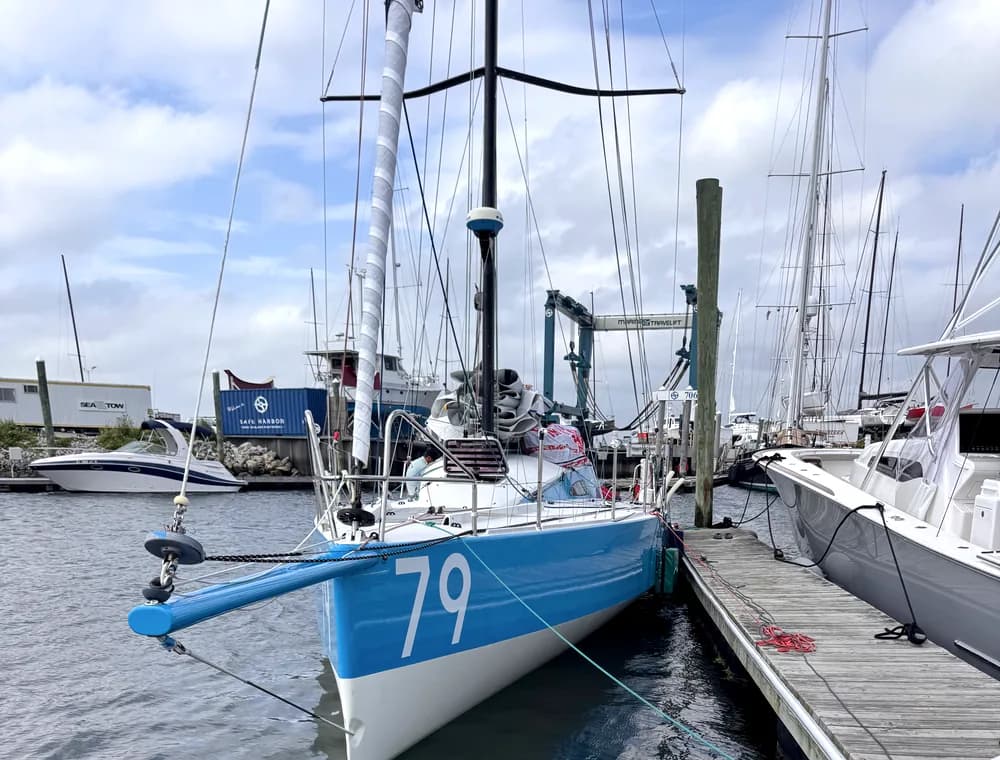 Blue sailboat docked in a marina slip